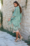 Close-up of mint green lace coverup layered over a printed dress with elephant and floral patterns.