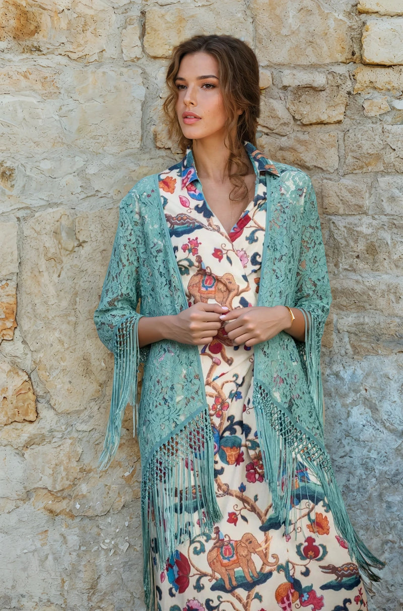 Side view of a mint green lace fringe coverup styled over a floral dress.