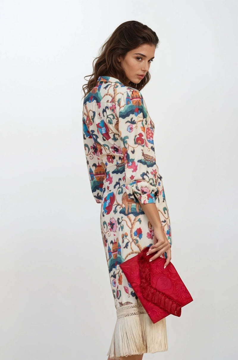 Back view of the same cream printed wrap dress with fringe hem, showing colorful print and 3/4 length sleeves.