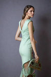 Back view of embroidered mint green dress showing deep V-back and fringe hem, paired with matching embroidered clutch.