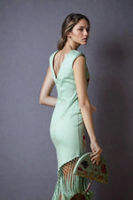 Back view of embroidered mint green dress showing deep V-back and fringe hem, paired with matching embroidered clutch.