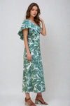 Side view of model in green tropical print top with ruffled sleeve detail.