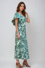 Side view of model in green tropical print top with ruffled sleeve detail.