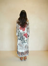 Back view of woman wearing leopard print maxi dress with large red floral design and long sleeves.