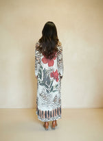 Back view of woman wearing leopard print maxi dress with large red floral design and long sleeves.