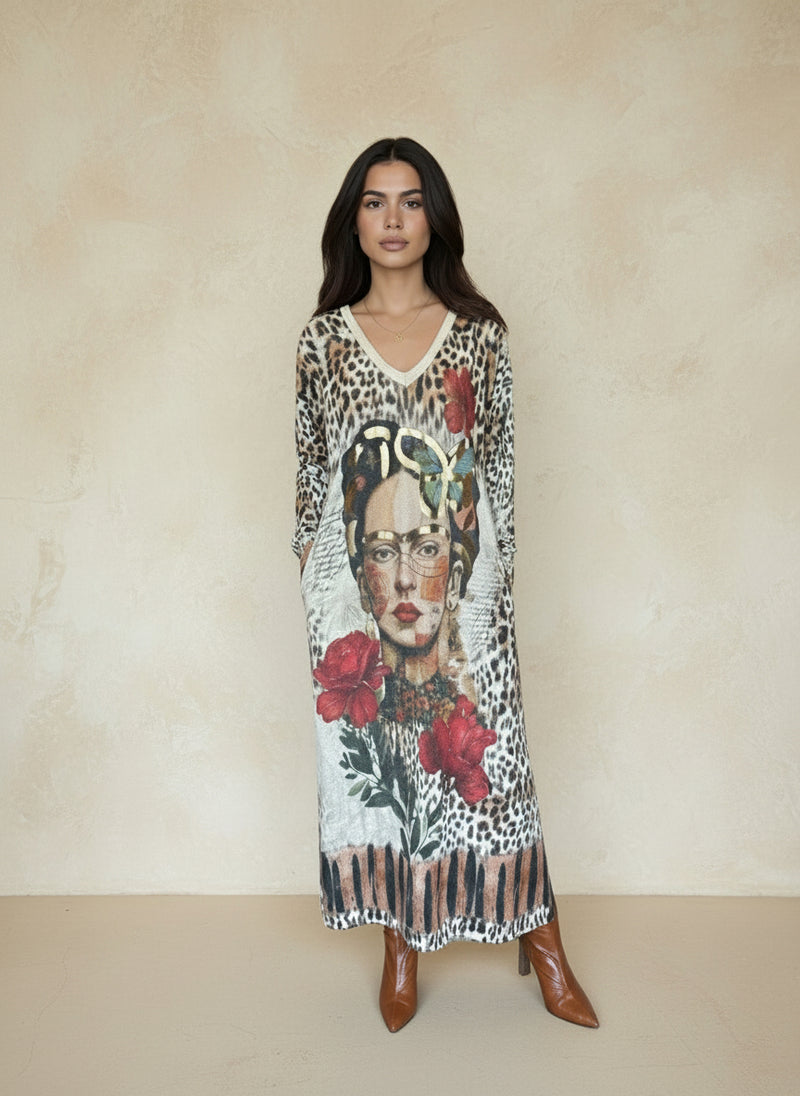 Woman wearing long leopard print maxi dress with artistic face and red floral design on front, styled with brown ankle boots.