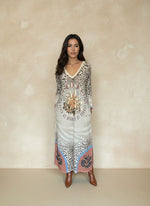 Woman wearing long leopard print maxi dress with sun and moon graphic and the phrase “Never Be Afraid of Change,” styled with brown ankle boots.