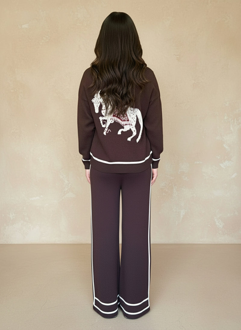 Back view of woman in a dark-brown knit loungewear set with a white embroidered horse motif on the sweater.