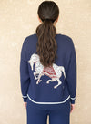 Back view of a navy knit sweater with a large white horse graphic and white trim, paired with matching knit pants.
