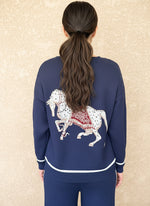 Back view of a navy knit sweater with a large white horse graphic and white trim, paired with matching knit pants.
