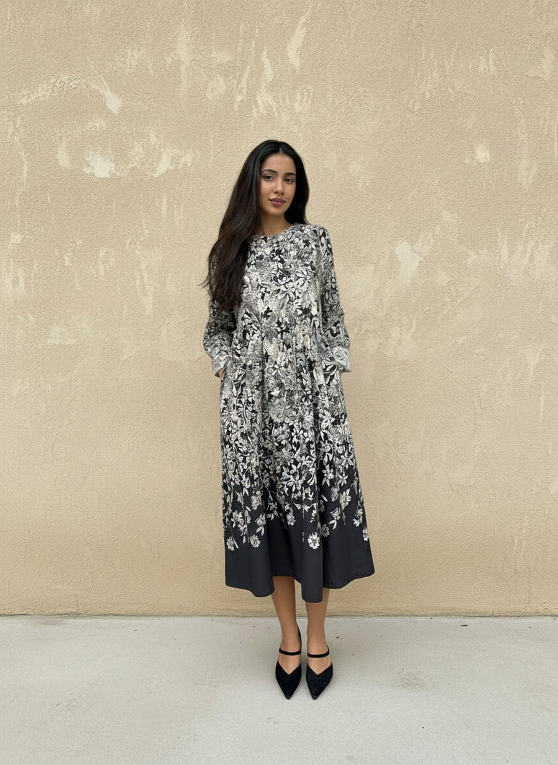 Full front view of a woman in a loose-fit black and white floral dress — feminine, comfortable midi dress with pockets.