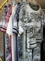 Stack of patterned cloths on a metal rack. All the colours.