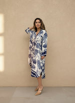 Woman in navy blue and white toile print long sleeve midi dress with V-neck collar.