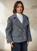 Woman wearing textured grey double-breasted peacoat with gold buttons.