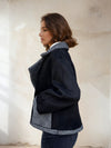 Side profile of model wearing black and grey wool-blend coat with oversized collar.