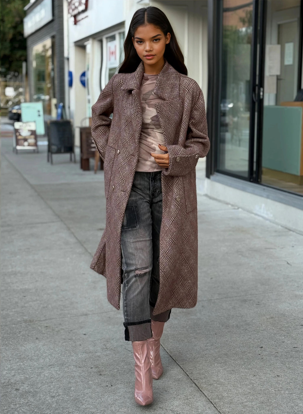 Model wearing a long brown textured wool coat with gold buttons, paired with distressed gray jeans and pink patent ankle boots, styled for fall street fashion