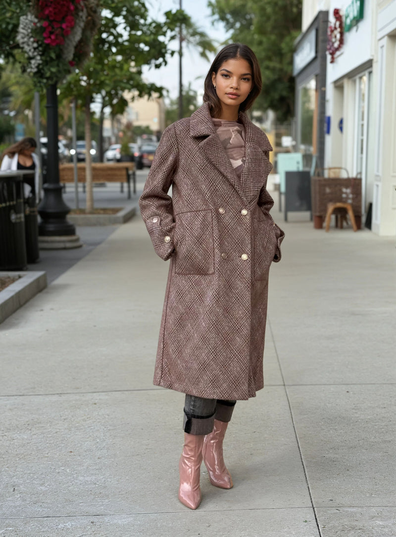 Model wearing a long brown textured wool coat with gold buttons, paired with distressed gray jeans and pink patent ankle boots, styled for fall street fashion