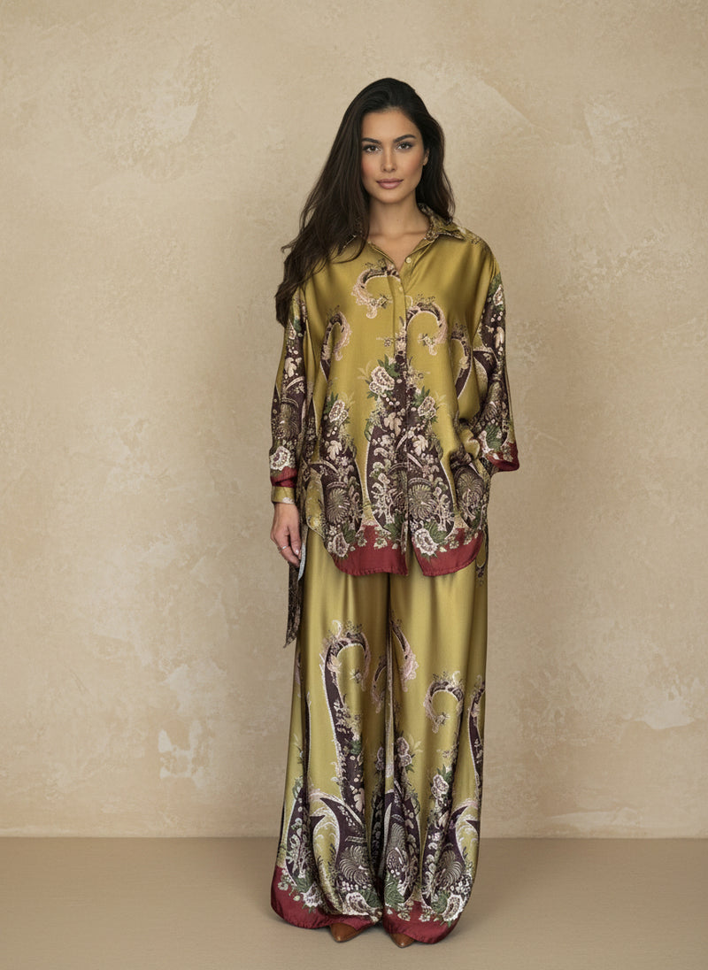 Front view of a woman in a chartreuse satin outfit with baroque floral detailing in burgundy and brown tones. Sophisticated coordinated set perfect for chic resort fashion.