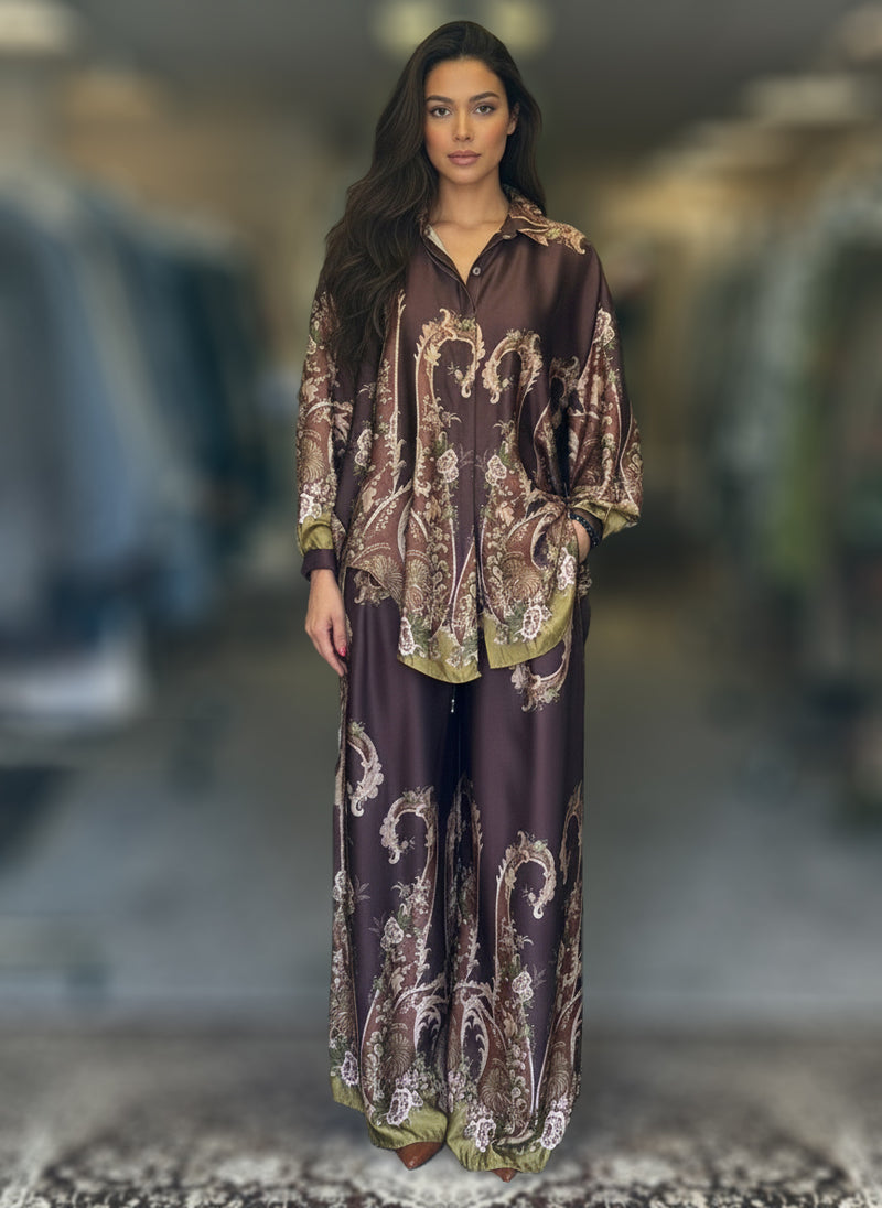 Model in a dark chocolate brown silk baroque print co-ord set with olive accents and wide-leg pants. Luxurious matching outfit with intricate detailing and rich tones.